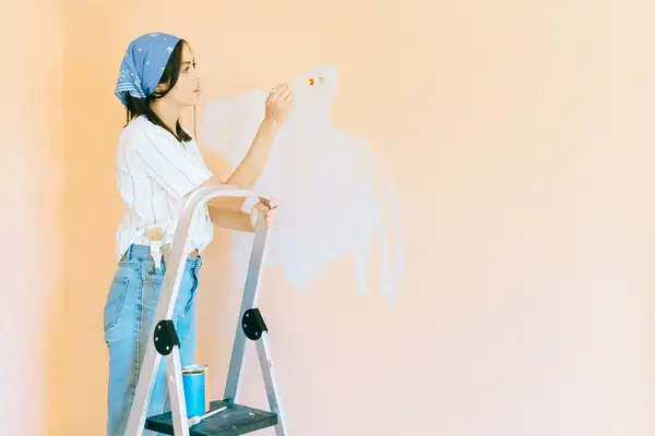 Interior painting in Jackson: painter on a stepladder rolling a wall